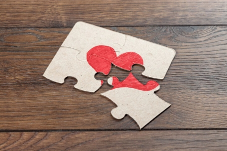 Parts of the puzzle form the heart, broken. The concept of divorce, quarrel, conflict.