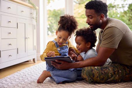 service member playing with his children