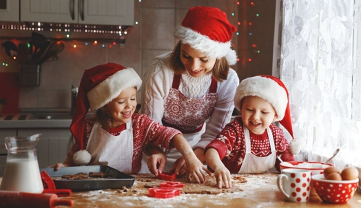 Happy family mother and children son and daughter bake cookies for Christmas.